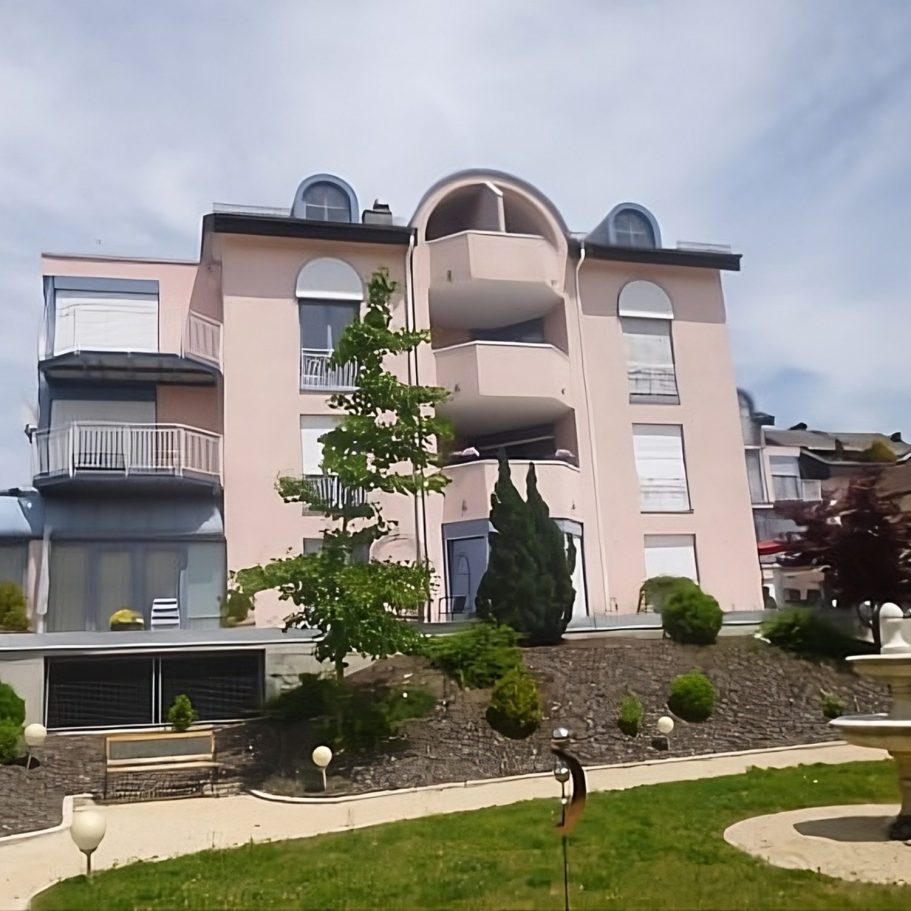 Modernes Seniorenwohnheim mit Balkonen, Terrasse und gepflegtem Garten.